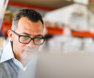 man in glasses looking at a computer