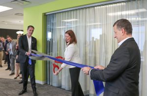 From left to right: Christoph Wollershiem, Lisa Gardner and Gary Sladic cutting the ribbon at the Woodlawn office re-opening event