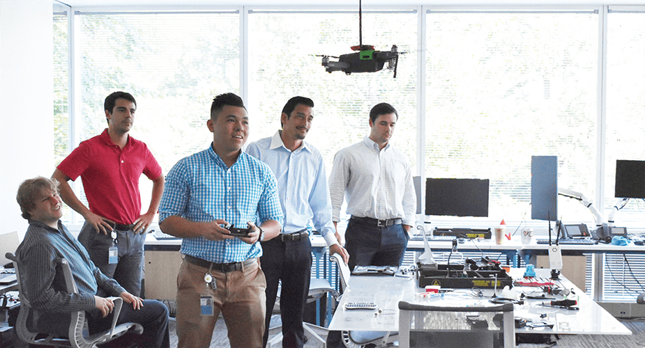 men testing a drone in an office