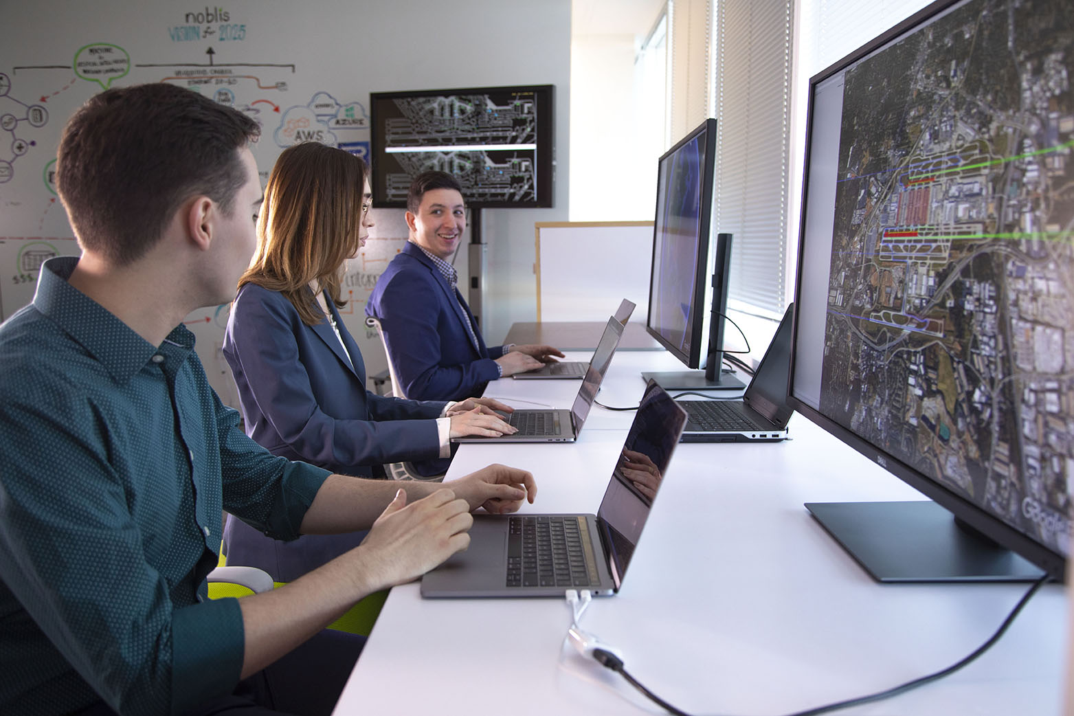 woman and two men all working on computers