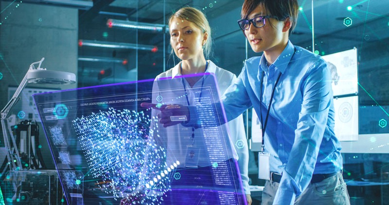 two professionals in business attire pointing at a screen with abstract data on it