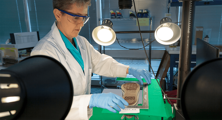 woman examining shoe in a lab