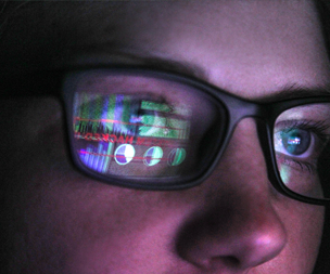woman with computer screen reflection in her glasses