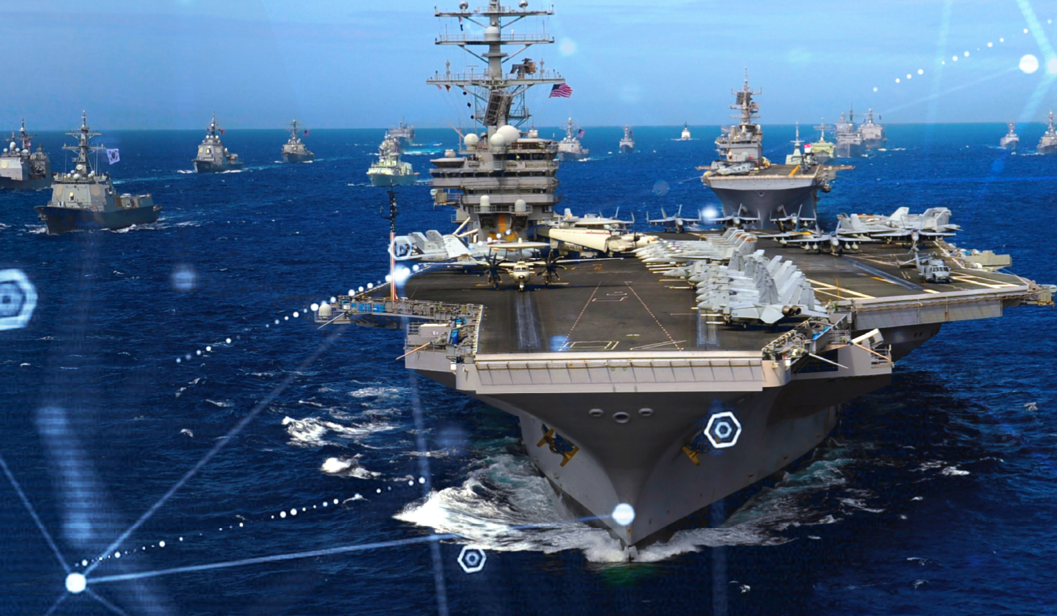 a fleet of US Navy ships on the ocean including carriers and destroyer class vessels