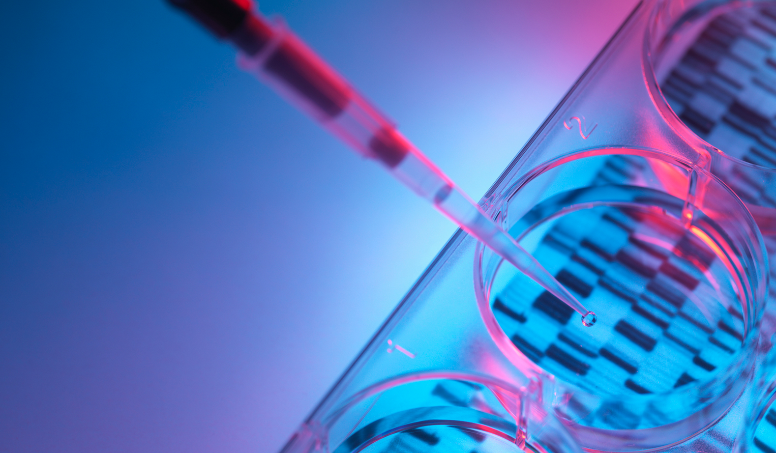 a close up of a liquid dropper in a lab hovering over a tube with a print out of DNA data