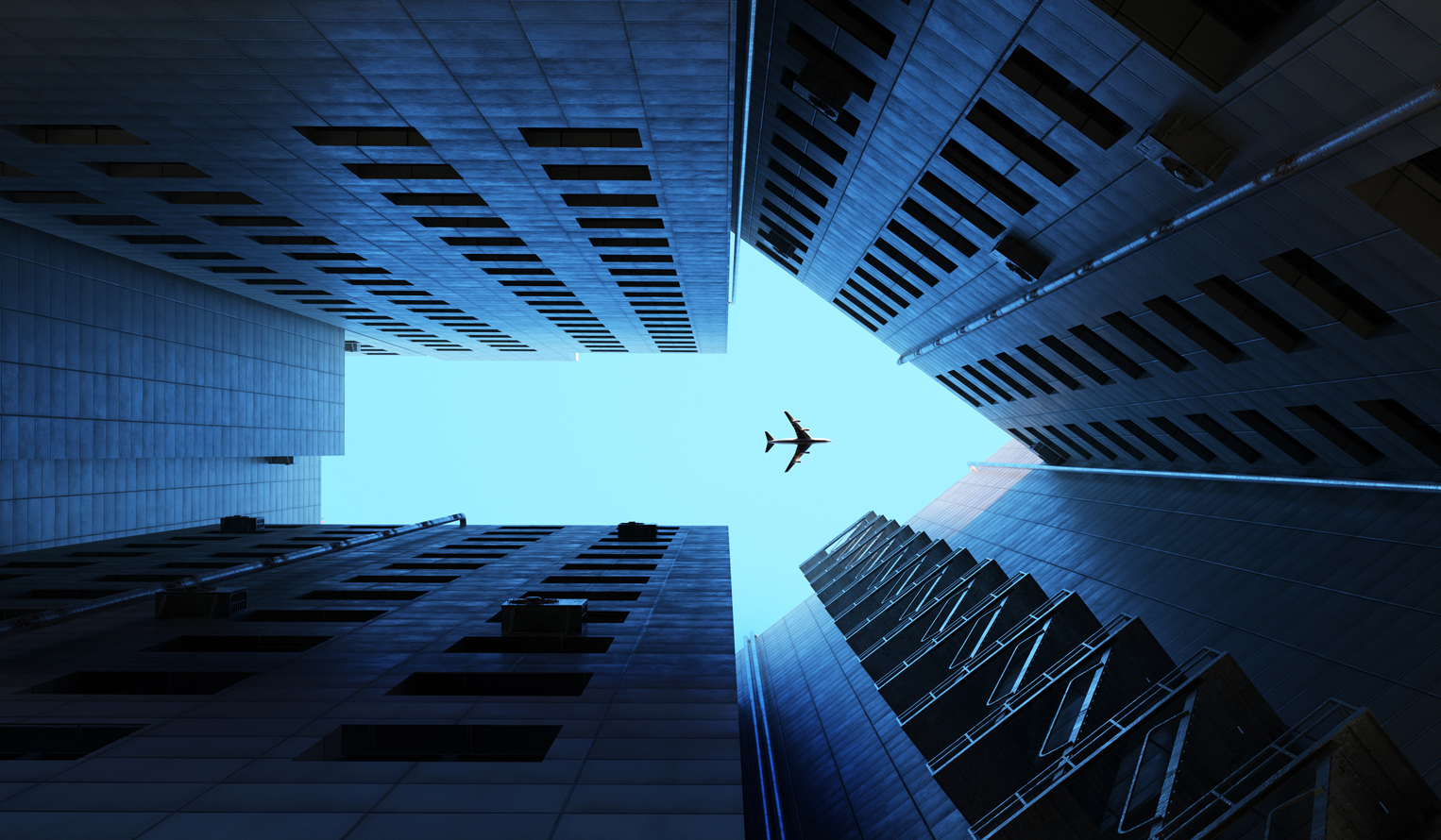 view looking up at a plan in the sky flying past tall buildings, building form the shape of an arrow
