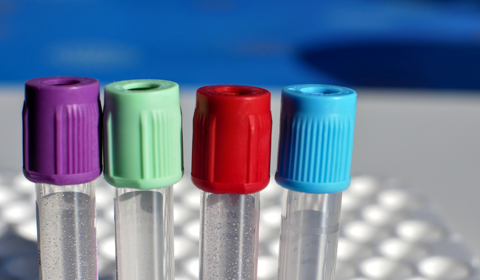 four glass sample tubes sit on a lab table